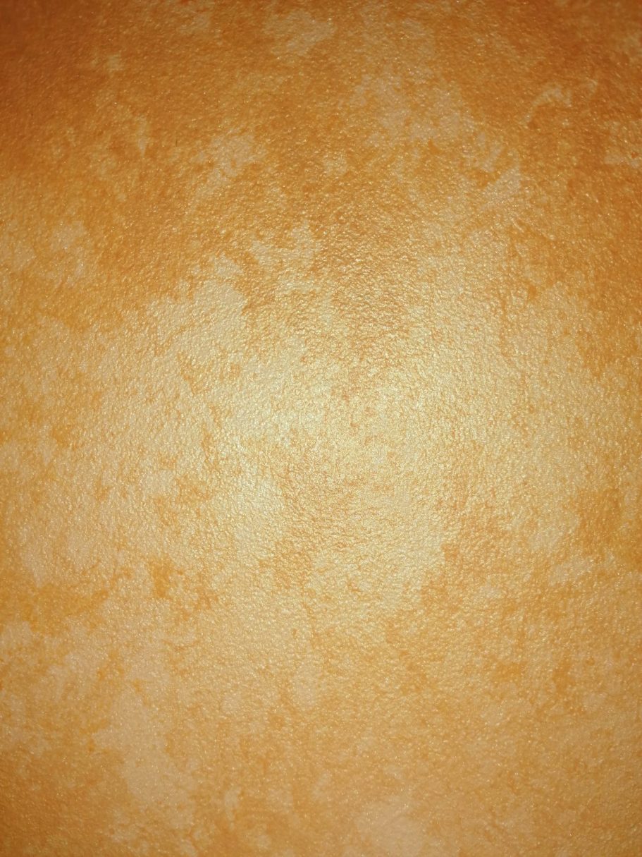 Textured orange wall with subtle variations in colour and pattern.