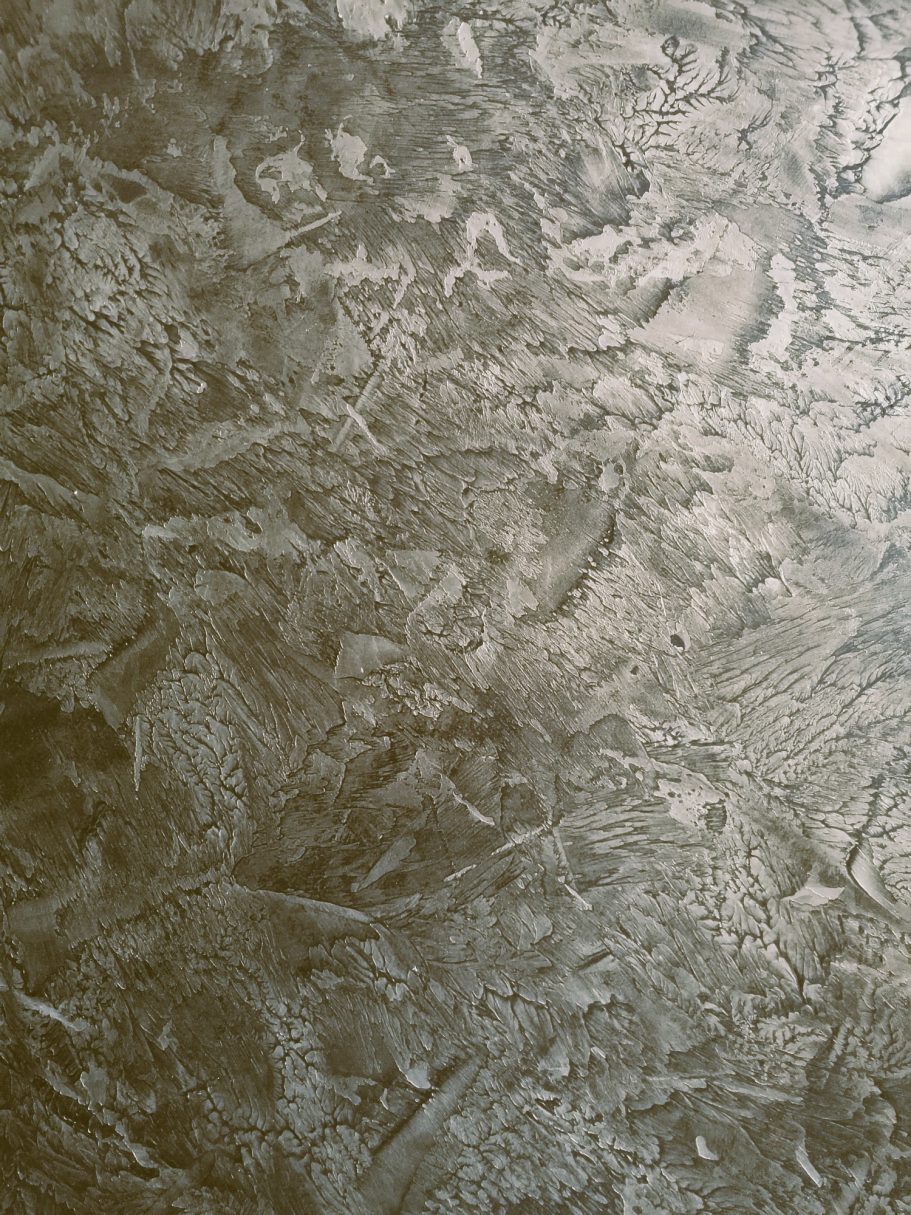 Textured surface with a subtle, metallic sheen in shades of gold and silver.